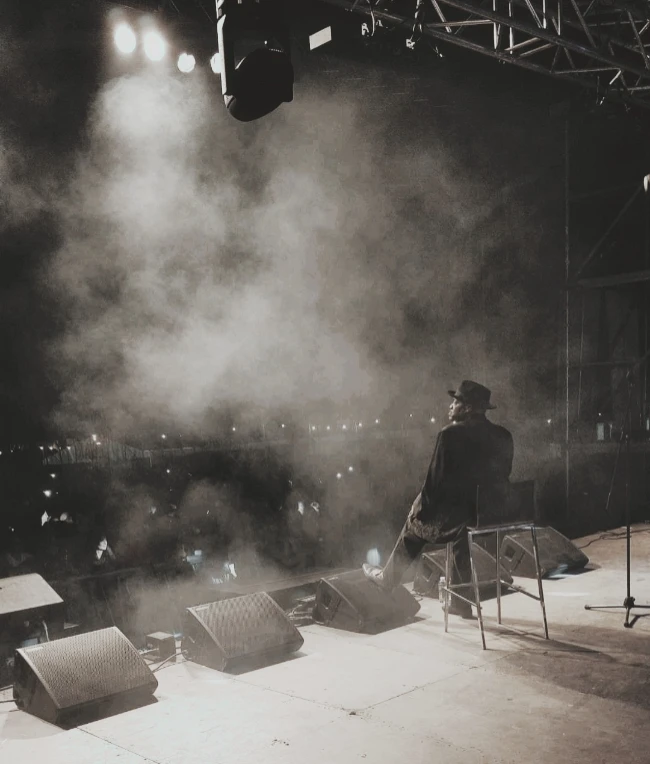 Speakers on festival stage with singer performing in smoke